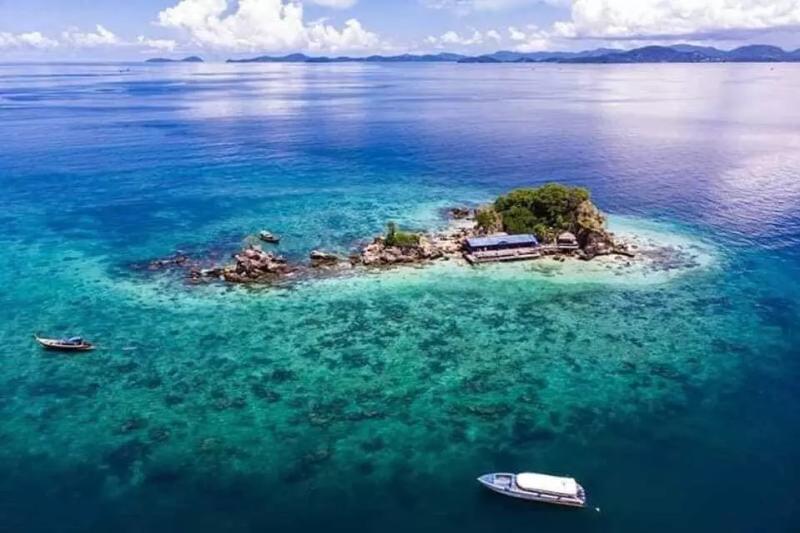A stunning aerial view of an idyllic island in Thailand, surrounded by crystal-clear turquoise water