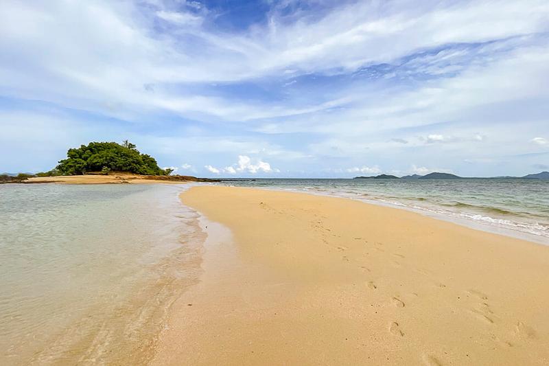 An aerial view of a pristine beach in Phuket, showcasing clear waters and the beautiful coastline of