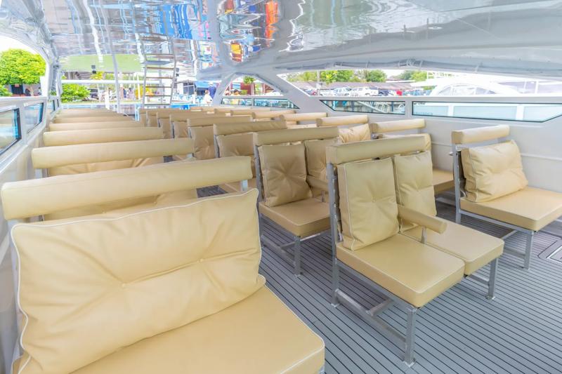 Interior of a luxury yacht featuring comfortable beige seating arranged neatly in rows.