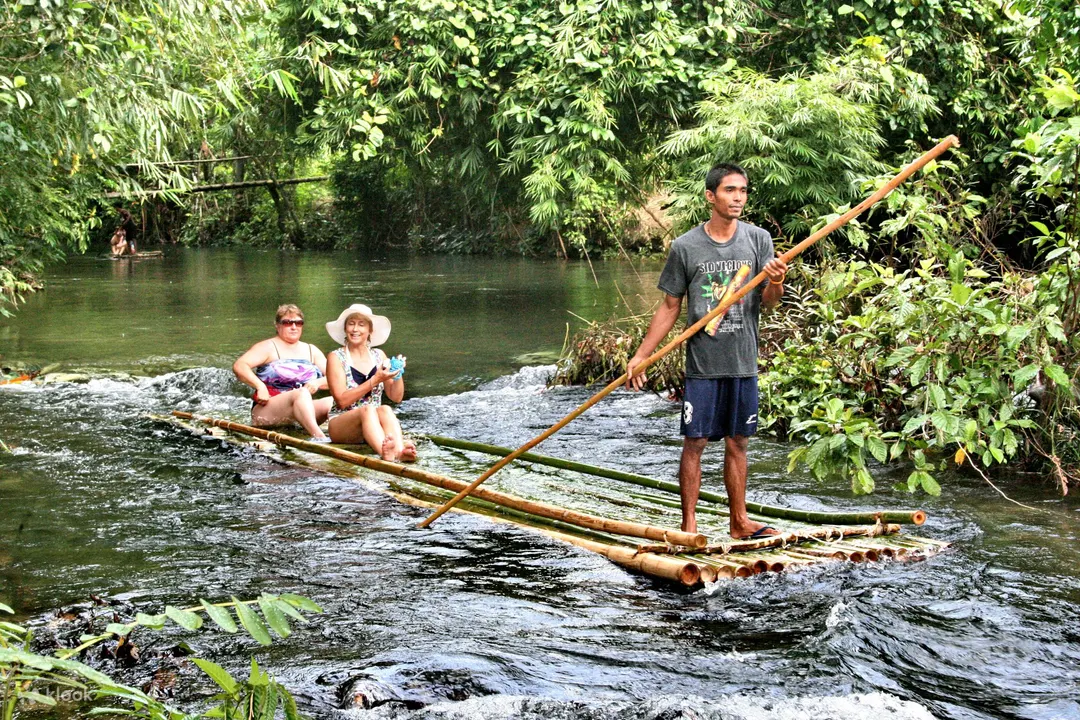 Experience the tranquility of bamboo rafting in Thailand, gliding down crystal-clear rivers surround